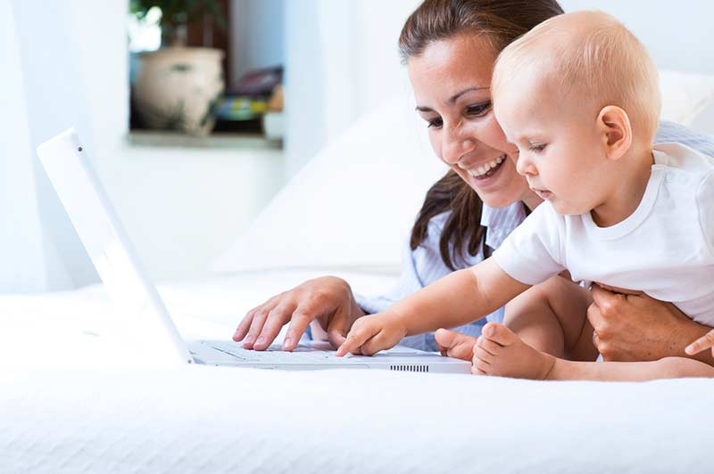 Woman and baby looking at a laptop.